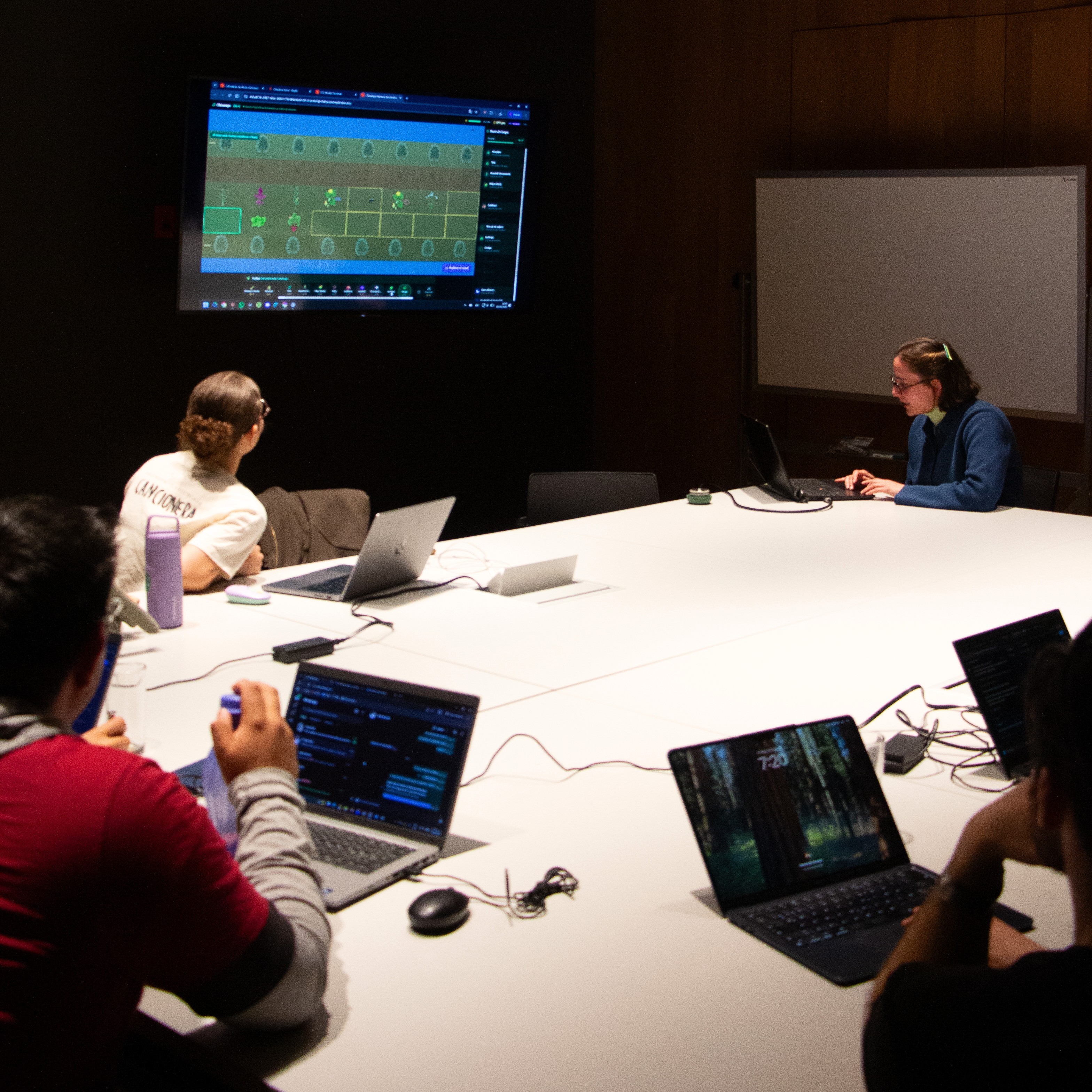 Participantes trabajando en sus laptops durante el evento